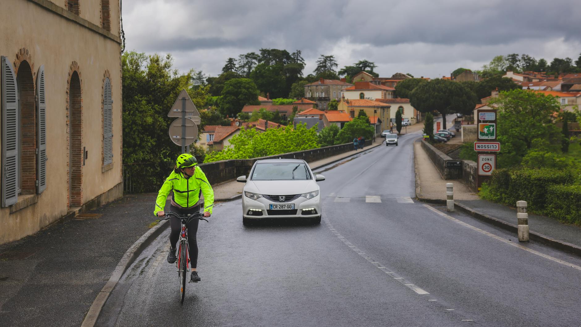 Cycliste sur une route de village français avec signalisation zone 30